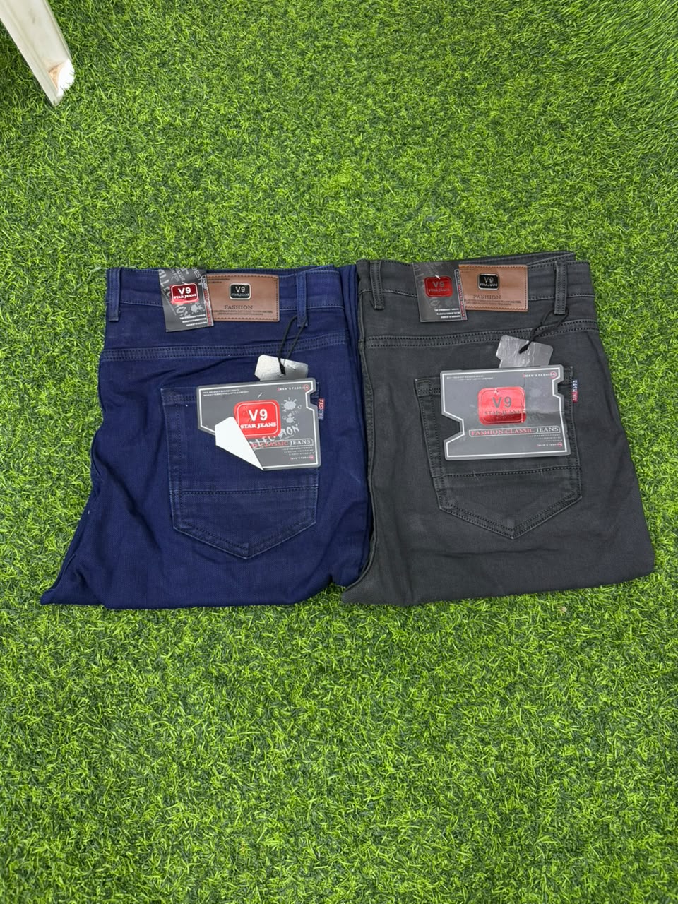 Two V9 Star Jeans in navy blue and charcoal black folded