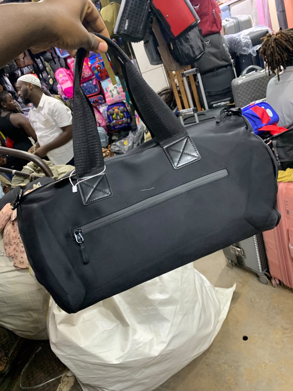 Original photo of black travel duffle bag with long handles and front zip pocket