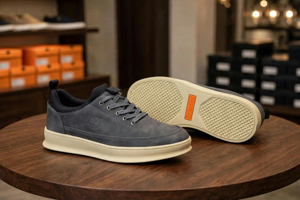Original grey sneakers showing stitched upper and cream outsole with orange accent