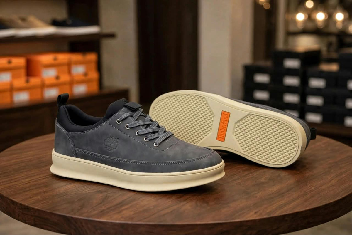 Original grey sneakers showing stitched upper and cream outsole with orange accent
