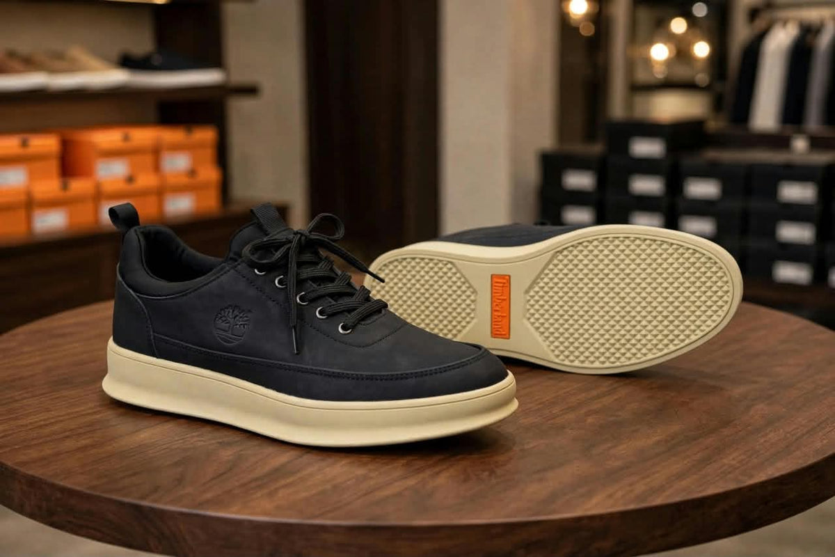 Original black lace-up sneakers showing cream outsole with orange accent