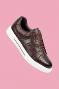 Brown sneaker with a pink background