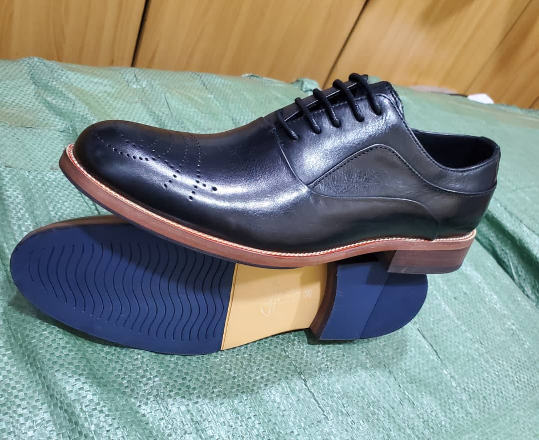 Original photograph of black perforated-toe gentle shoes