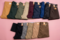 Assorted men's khaki pants on a soft pink background