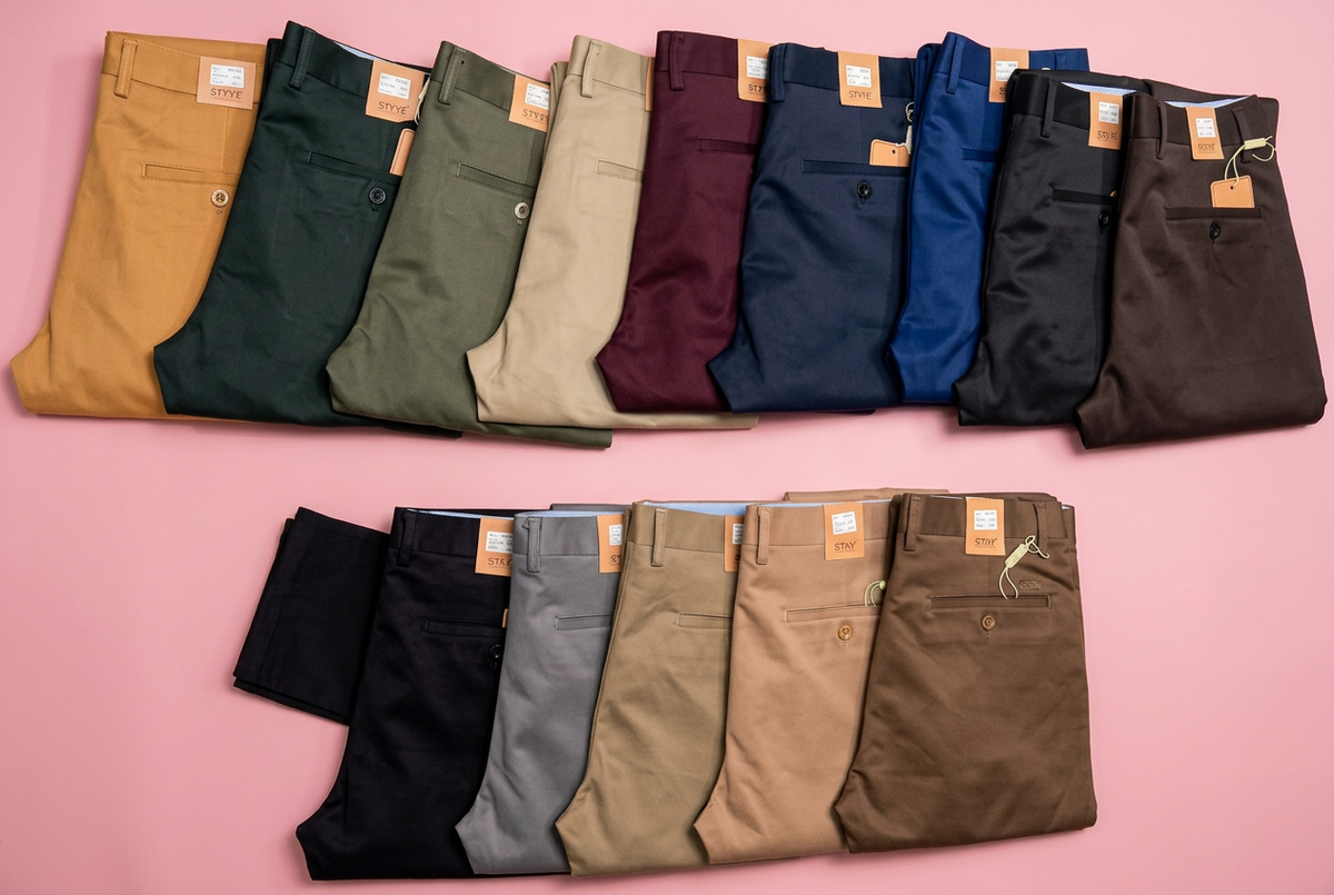 Assorted men's khaki pants on a soft pink background