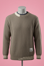 Taupe textured knit sweater with white stripe trim on a mannequin against a soft pink background