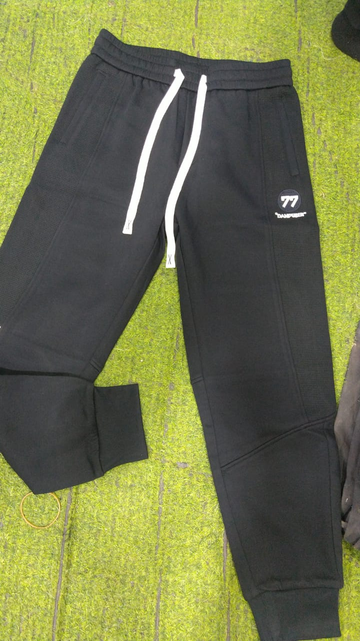 Original photo of black drawstring joggers with cuffed ankles and 77 emblem