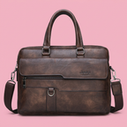 Brown Jeep briefcase with twin handles and shoulder strap on soft pink
