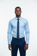 Lifestyle - young African man wearing sky blue Verso Ceremony shirt, royal blue tie and navy pants