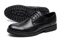 Black wingtip brogue shoes with lug soles on white background