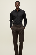 Full length model wearing Verso Black Dress Shirt and Khaki Dark Brown Pants on cream background