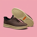 Brown lace-up sneakers with cream soles on soft pink background