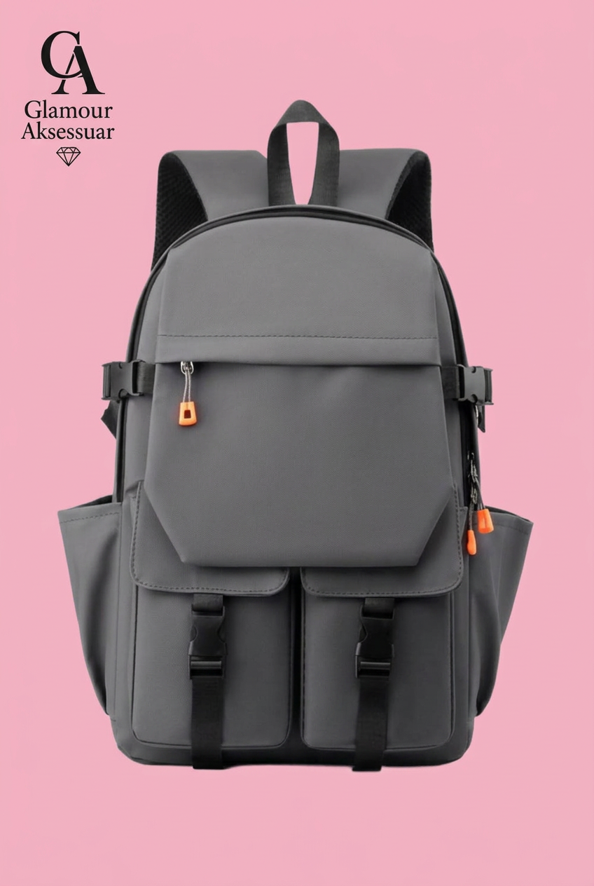 Grey backpack with two lower buckle pockets and orange zip accents on soft pink background