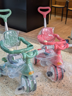 Kids green and pink tricycles in packaging