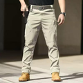 Men's light khaki tactical cargo pants with zippered pockets and panel stitching