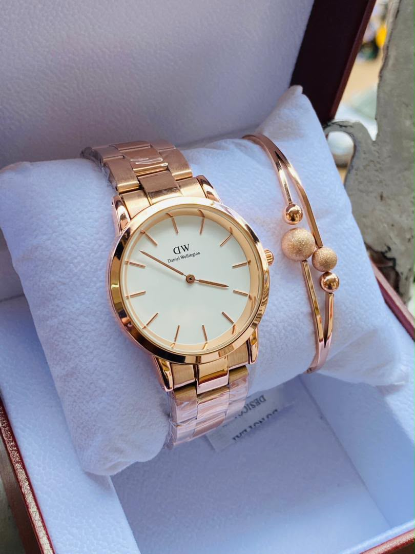 Gold-tone minimalist watch and beaded bracelet on cushion in presentation box