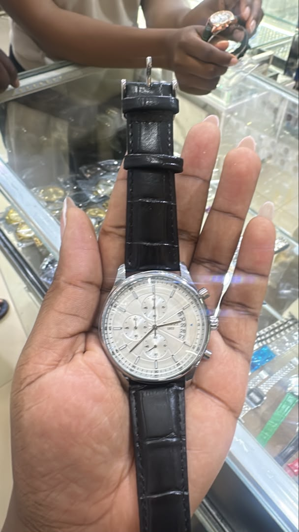 Silver-tone round watch with a light dial and black textured strap