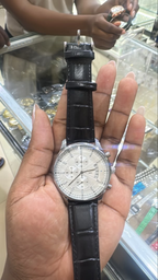 Silver-tone round watch with a light dial and black textured strap