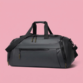 Black duffle bag detail on soft pink background