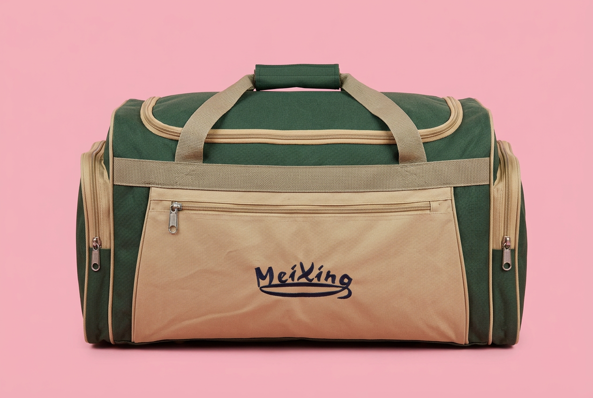 Green and beige front-pocket travel duffel bag on a soft pink background