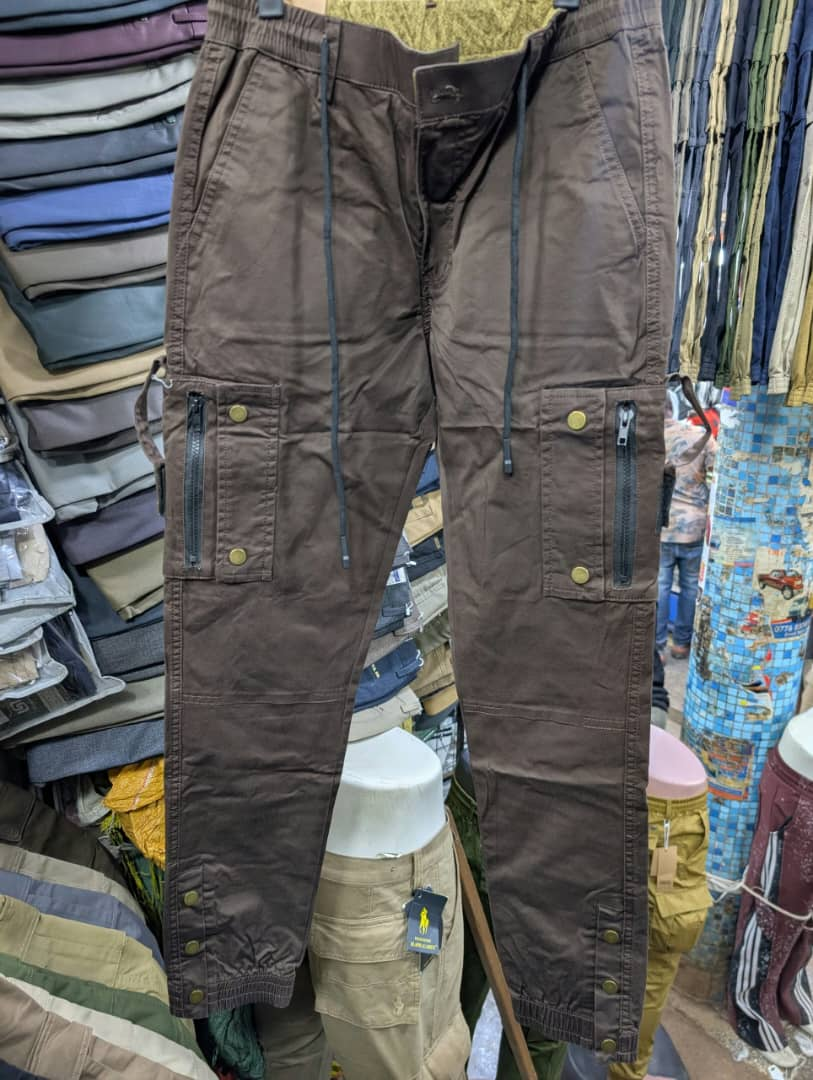 Men's brown cargo pants with zippered pockets and brass snap buttons