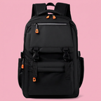 Black multi-pocket backpack with orange zipper pulls on soft pink background