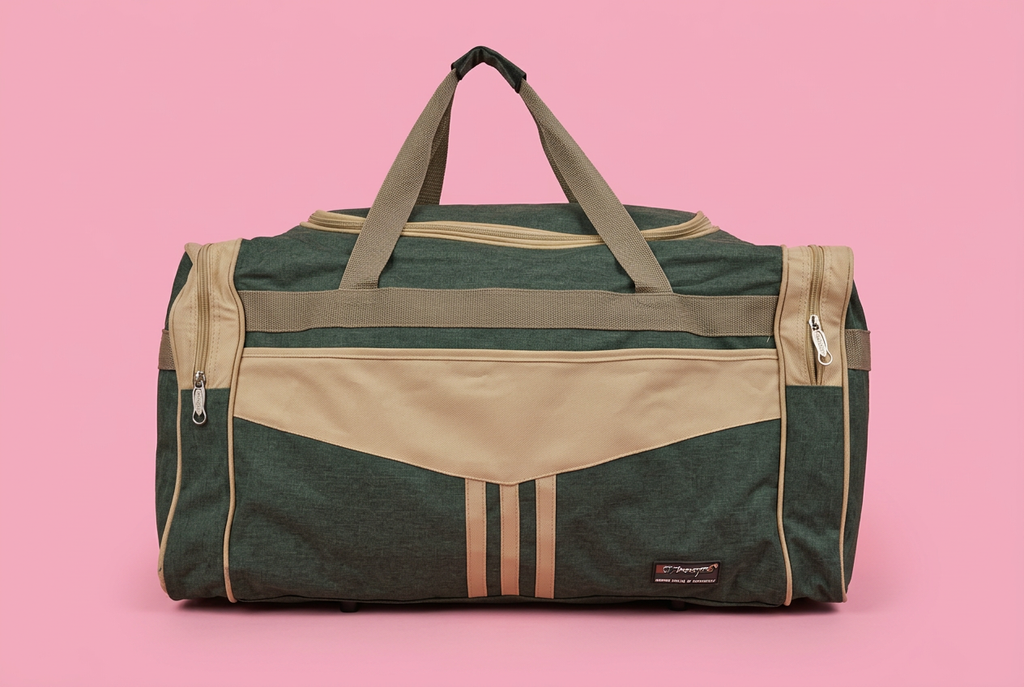 Dark green and beige travel duffel bag on soft pink background