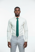 Lifestyle - young African man wearing cream Monza shirt, forest green tie and light grey pants