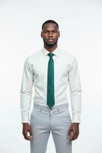 Lifestyle - young African man wearing cream Monza shirt, forest green tie and light grey pants