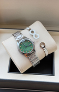 Green dial silver watch and two bracelets displayed on cushion in box