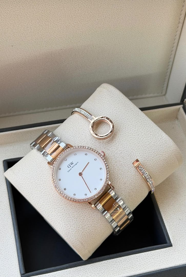 Two-tone white dial watch and two slim bracelets displayed in box