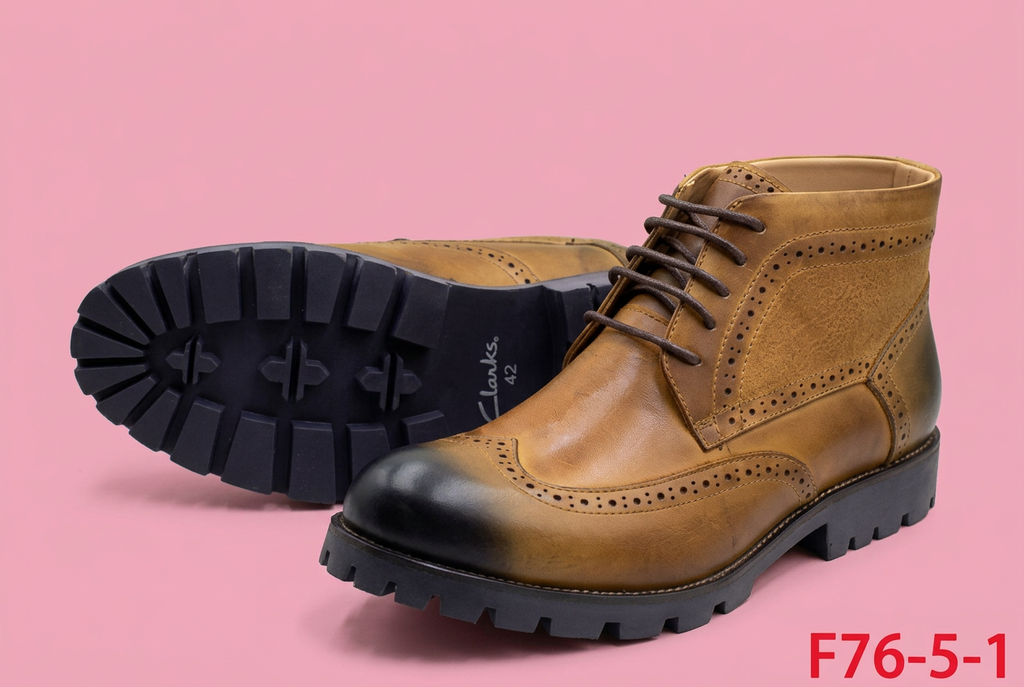 Tan brogue ankle boots on soft pink background