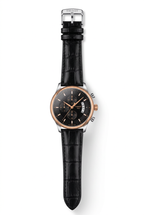 Black-dial watch with rose-gold-tone case and black embossed strap on white background