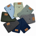 Folded men's chinos in assorted colours on a white background